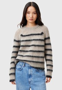 Beige gestreifter Pullover mit schwarzen horizontalen Linien, aus weichem strukturiertem Stoff, mit Rundhalsausschnitt und Rippbündchen. Kombiniert mit blauen Jeans.