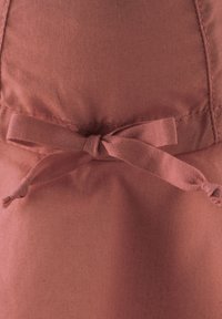 Stoff in Rostfarbe mit weicher Textur, versehen mit einem gebundenen Schleifendetail an der Taille und sauberen Nähten, geeignet für legere Kleidung.