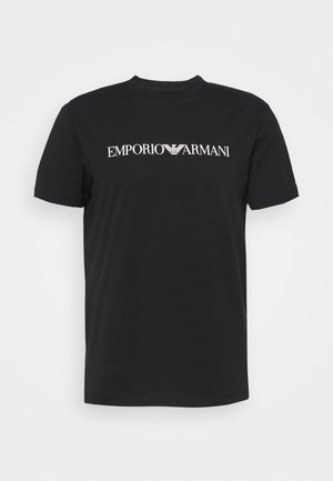 Crna pamučna majica s bijelim logotipom "EMPORIO ARMANI" na prednjem dijelu, klasičnog okruglog izreza i kratkim rukavima. Glatka tekstura.