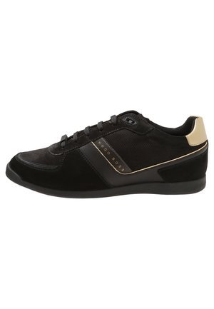 Baskets basses noires avec laçage sur le devant, logo Hugo Boss sur le côté, dessus en mesh et cuir, accent beige au talon, et semelle en caoutchouc plate.