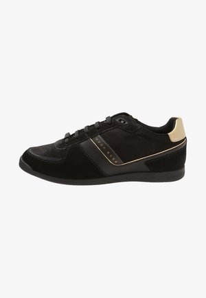 Zwarte lage sneaker met veters aan de voorkant, Hugo Boss-logo aan de zijkant, bovenwerk van mesh en leer, beige hielaccent en platte rubberen zool.