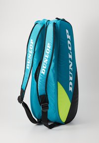 Dunlop Rucksack mit einem tealfarbenen Stoffkörper, schwarz und neongrünen Akzenten, gepolsterten Trägern und einem großen Logo an der Seite. Mit Reißverschluss.