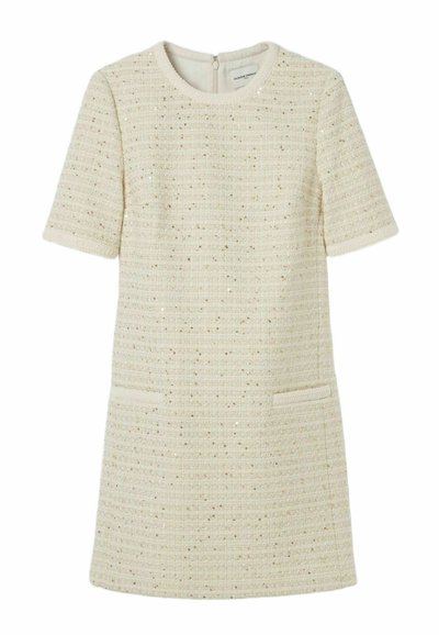 Robe crème à manches courtes en tissu texturé avec des fils métalliques subtils, dotée de deux poches avant et d'une fermeture éclair au dos.