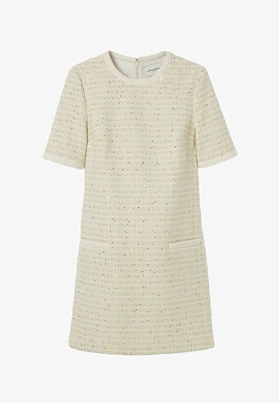 Robe crème à manches courtes en tissu texturé avec des fils métalliques subtils, dotée de deux poches avant et d'une fermeture éclair au dos.