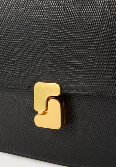 Μαύρο τσαντάκι χειρός από δέρμα με υφή, με χρυσό γεωμετρικό κούμπωμα που αποτελείται από δύο διαπλεκόμενα κομμάτια σε σχήμα L.