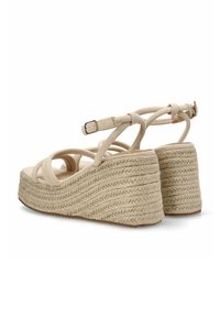 Sandalias de cuña beige con diseño de correas cruzadas, fabricadas en tela. Suela texturizada similar a una cuerda, correa ajustable para el tobillo y una base sólida.