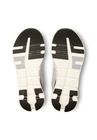 Shoe sole in black and white with a textured pattern, featuring a thick rubber base and flexible grooves for traction and support.