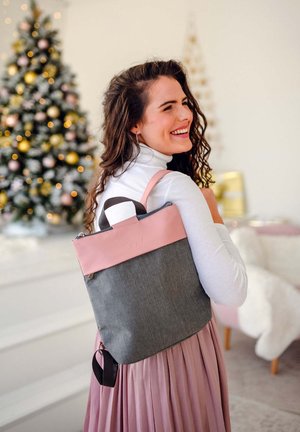 Rucksack mit einem pinkfarbenen oberen Abschnitt und einem grauen Körper, ausgestattet mit einem Reißverschluss, zwei Riemen und einem Griff. Der Stoff hat eine glatte Textur.