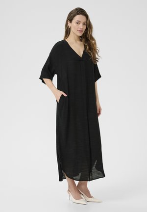 Black, knee-length dress with a V-neck, short sleeves, and side pockets, made from lightweight fabric, featuring a loose fit and subtle texture.