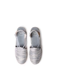 Sandali espadrille argentati con tomaia texturizzata, design raccolto, cinturini elastici e suole in juta intrecciata. Tessuto leggero e traspirante.