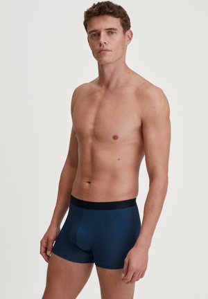 navyblaue Boxershorts mit feinen horizontalen Streifen, elastischem Bund und taillierter Passform. Das Material wirkt glatt mit einer subtilen Textur.
