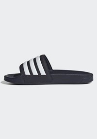 Dark blue slide sandal with three white stripes on the strap, made of textured material, featuring a flat sole without distinct patterns.