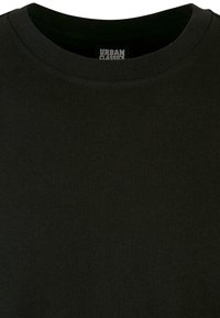 Čierne tričko s okrúhlym výstrihom, vyrobené z hladkej bavlnenej látky. Obsahuje etiketu "URBAN CLASSICS" umiestnenú pri výstrihu. Bez vzorov alebo akcentov.