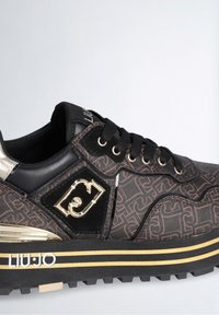 Baskets à motifs noirs et marrons avec lacets noirs, logo doré, semelle beige à rayures dorées et col rembourré à la cheville.