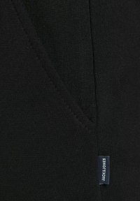Zwarte katoenen T-shirt met V-hals ontwerp, zachte textuur en een klein logo label van Jack & Jones op de zijnaad.