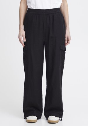 Pantalons cargo noirs en tissu doux, dotés d'une taille élastique, de poches latérales et d'une coupe ample et décontractée. Les accents incluent des poches cargo latérales.