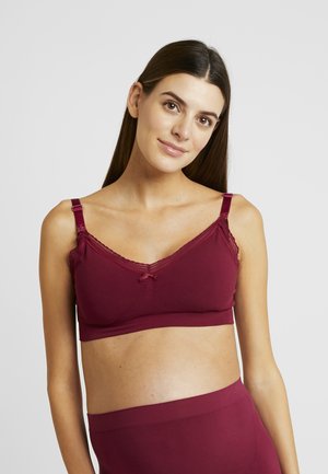 Bordeaux bralette met kantafwerking, verstelbare bandjes, zachte stof en een strikdetail in het midden. Ontworpen voor comfort en ondersteuning.