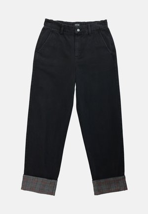 Melni denima bikses ar brīvu piegriezumu un sarullētām piedurknēm, kurām iekšā ir gumijas audums ar rakstu. Funkcionālas kabatas un pogu aizdare jostas vietā.