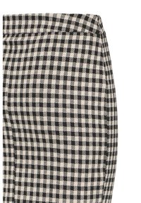 Schwarz-weiße karierte Hose mit strukturiertem Bund und texturiertem Stoff. Das Muster besteht aus abwechselnd großen und kleinen Quadraten.
