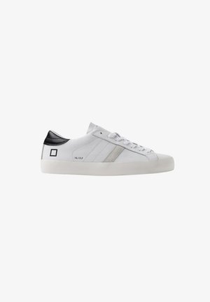 Sneakers in pelle bianca con dettagli grigi, caratterizzati da un tallone e un logo neri. Il design include una parte frontale con lacci piatti e una suola texturizzata.