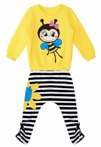 Maglietta gialla a maniche lunghe con grafica di ape e pantaloni a strisce nere con una toppa a forma di fiore giallo. In morbido misto cotone con polsini elasticizzati.