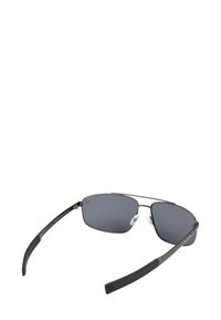 Ocelový rám obdélníkových slunečních brýlí s tmavě šedými čočkami a černými gumovými konci nožiček, zobrazené z mírně nakloněného předního pohledu.