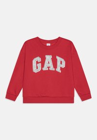 Sarkana džemperis ar baltām blokiem burtiem "GAP" uz krūtīm, garām piedurknēm, apaļu kakla izgriezumu, ribotām aprocēm un apakšmalu. Maiga tekstūra.