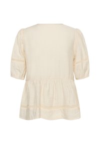 Blouse couleur crème à manches mi-longues bouffantes, détails en dentelle sur les manches et l’ourlet, coupe ample et légèrement évasée, vue de dos.