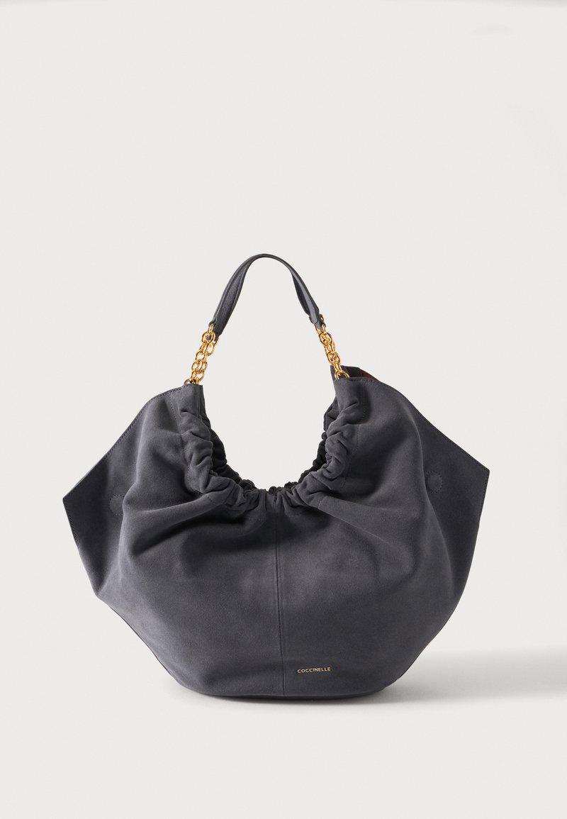 Sac à main doux en daim gris foncé avec haut froncé, chaîne dorée et poignées en cuir, avec petite étiquette dorée de marque au centre devant.