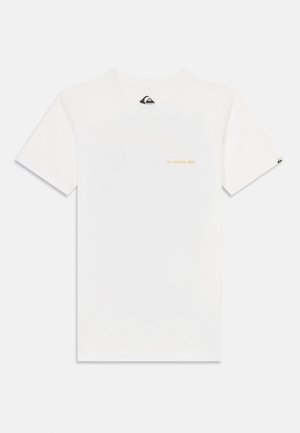 Camiseta blanca de algodón con mangas cortas, que presenta un pequeño texto de logo en naranja en el lado izquierdo del pecho y una etiqueta negra en la manga derecha.