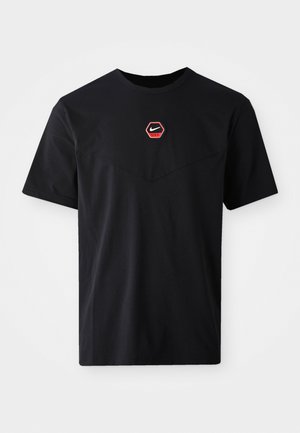 Black Nike t-shirt with a crew neck, short sleeves, a hexagonal red logo on the chest, and a textured v-shaped design at the front.