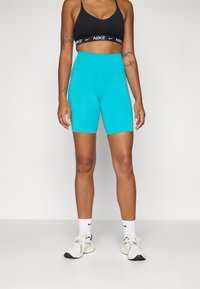 Shorts Nike turcoaz cu talie înaltă și un design elegant. Prezintă o textură netedă și cusături în contrast, însoțite de un sutien sport negru.