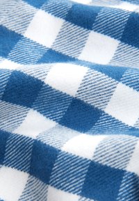 Weicher Stoff mit blau-weiß kariertem Muster, das abwechselnd aus einfarbigen und strukturierten Quadraten besteht.