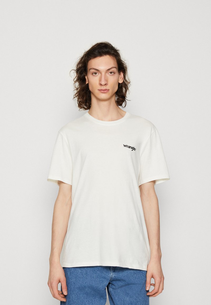 T-shirt bianco in cotone con scollatura rotonda e maniche corte, caratterizzato da un piccolo logo "wrangle" nero sulla parte sinistra del petto.