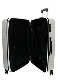 Valise rigide à roulettes avec un extérieur gris clair arborant un motif de logo répété, un intérieur noir et une ouverture à double zip.