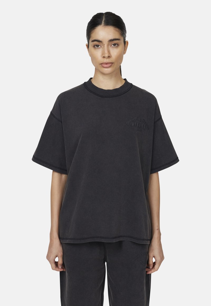 T-shirt nera in cotone oversize con maniche corte, scollatura a girocollo ribbed e dettaglio logo in rilievo sul lato sinistro del petto. Texture liscia.