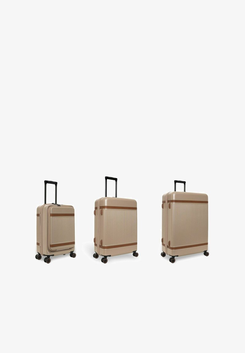 Trois valises beiges avec des accents marron, positionnées verticalement avec des poignées noires étendues et quatre roulettes pivotantes, présentées en tailles petite, moyenne et grande.