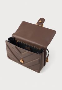 Bolsa de mão em pele castanha com quilting em padrão zigzag, acessórios em dourado, fecho magnético e forro interior preto com um bolso com fecho.