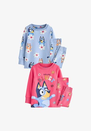 Två set barnpyjamasar: ett i ljusblått med tecknade hundar och blommor, och ett annat i rosa med en stor hundillustration och färgglad text.