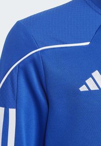 Blaues Sportoberteil aus strukturiertem Stoff. Merkmale weißen Akzenten und einem Adidas-Logo. Erhältlich in einem taillierten Design mit Rundhalsausschnitt.