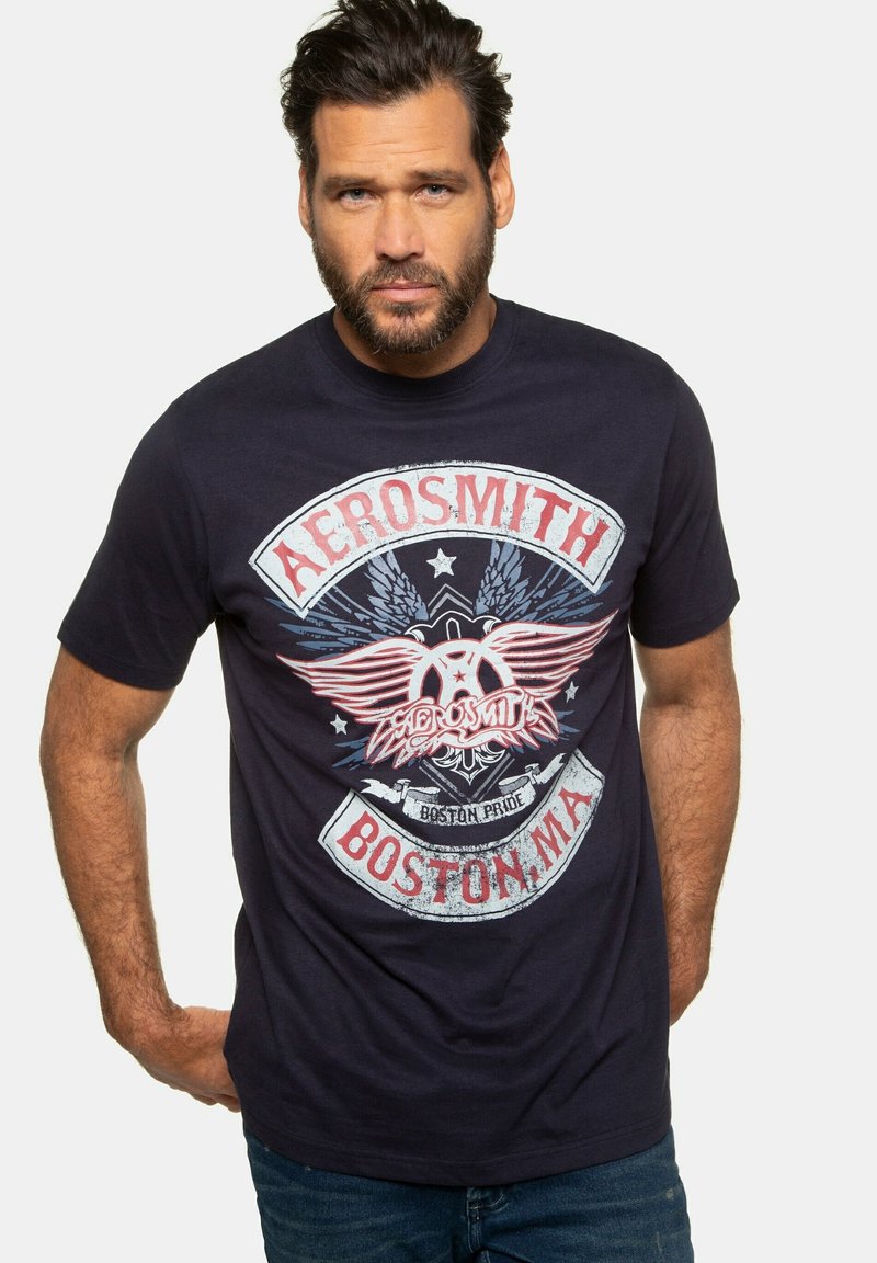 Námorně modré bavlněné tričko s grafickým potiskem křídel a textem: "Aerosmith Boston, MA" v červené a bílé barv�ě. Krátké rukávy, klasický kulatý výstřih.