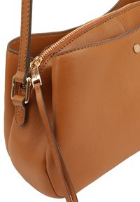 Bruine leren crossbody tas met een gestructureerde afwerking, gouden rits en verstelbare schouderriem. Kenmerkt zich door een eenvoudig, stijlvol ontwerp.