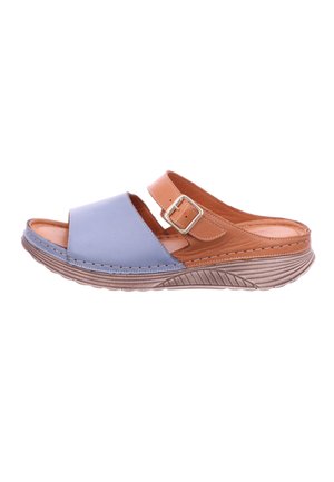 Two-tone slide sandals featuring a soft blue leather upper and tan leather accents. Textured sole with ridges for grip. Adjustable strap with buckle.
