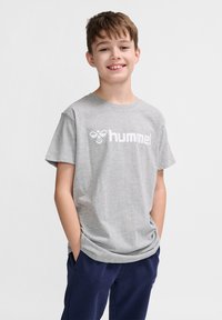 Tricou din bumbac gri, cu mâneci scurte și guler rotund, având un logo alb "hummel" imprimer pe față.