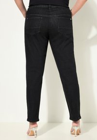 černé džíny z denimu s slim fit střihem, vybavené zadními kapsami a rovnou nohavicí. Materiál má hladkou texturu, doplněnou o stříbrné kování.