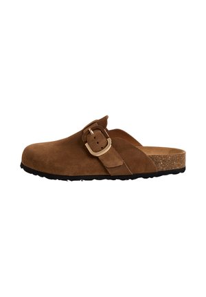 Brown suede clog with a wide strap and a metal buckle, cork midsole, and a black rubber sole, featuring a smooth, textured surface.
