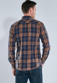 Karierte Hemd in Blau-, Orange- und Brauntönen; weicher Stoff; Button-Down-Kragen; abgerundeter Saum; verfügt über Brusttaschen und Knopfmanschetten.
