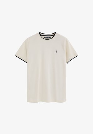 Cremefarbenes T-Shirt mit kurzen Ärmeln und schwarzem Besatz am Kragen und an den Ärmeln, kleines schwarzes Polo-Spieler-Logo auf der linken Brust.