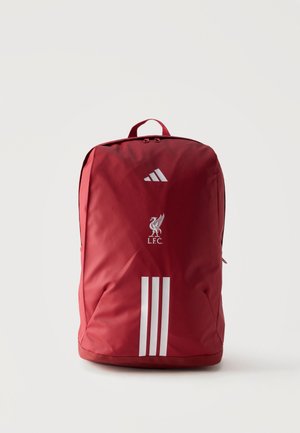 Czerwony plecak Adidas z trzema białymi paskami, logo Liverpool FC i górną rączką, pokazany na jednolitym jasnym tle.