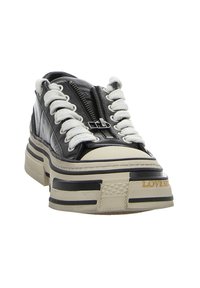 Schwarzer Ledersneaker mit weißen Schnürsenkeln, Reißverschluss, mehrschichtiger Plateausohle in Beige und Schwarz, mit strukturierten Akzenten und Logodetail.